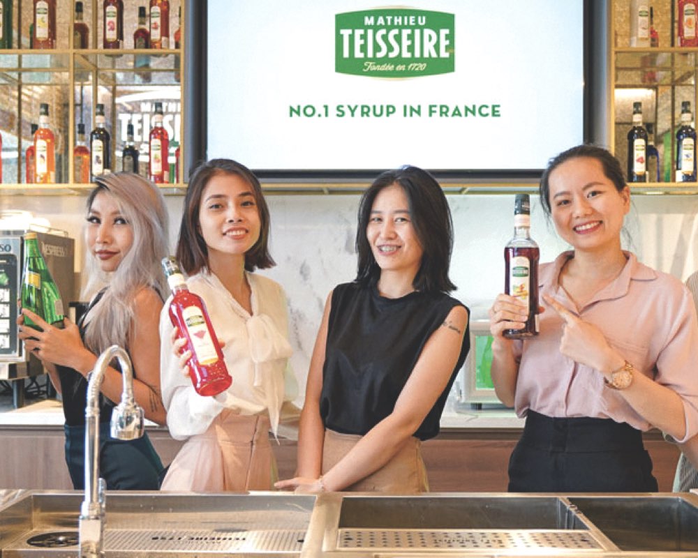 Teisseire bottles being shown by women